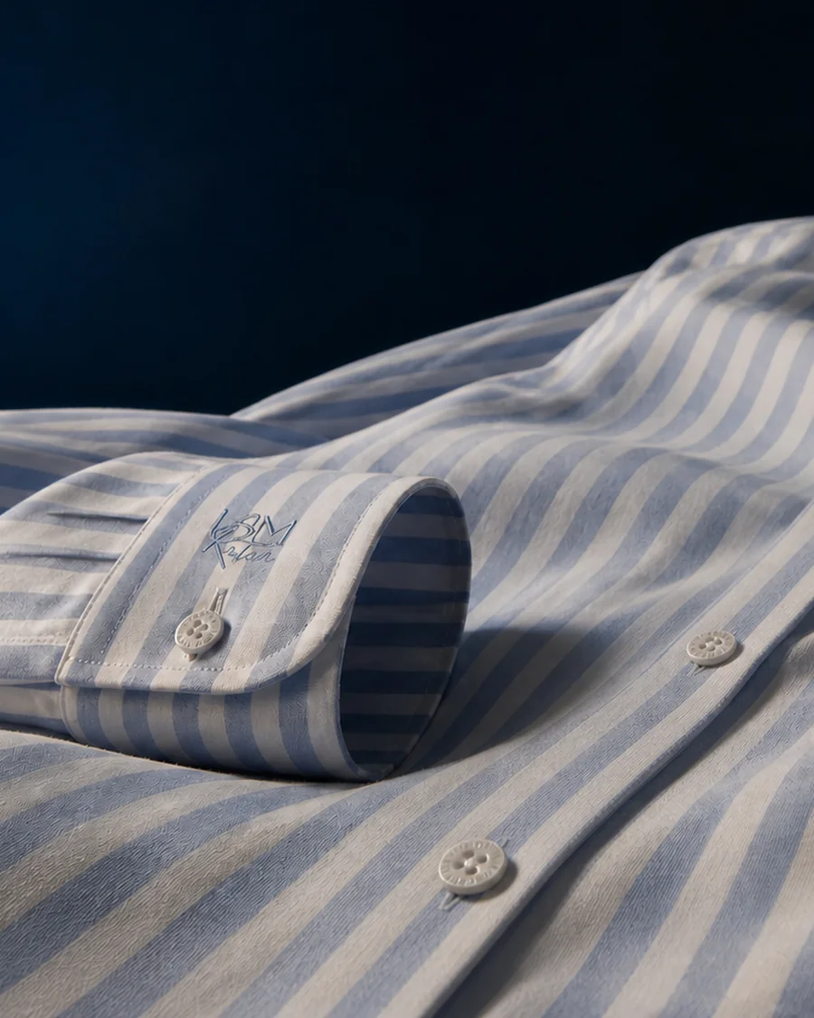 A blue striped shirt, the house signature embroidered at the cuff