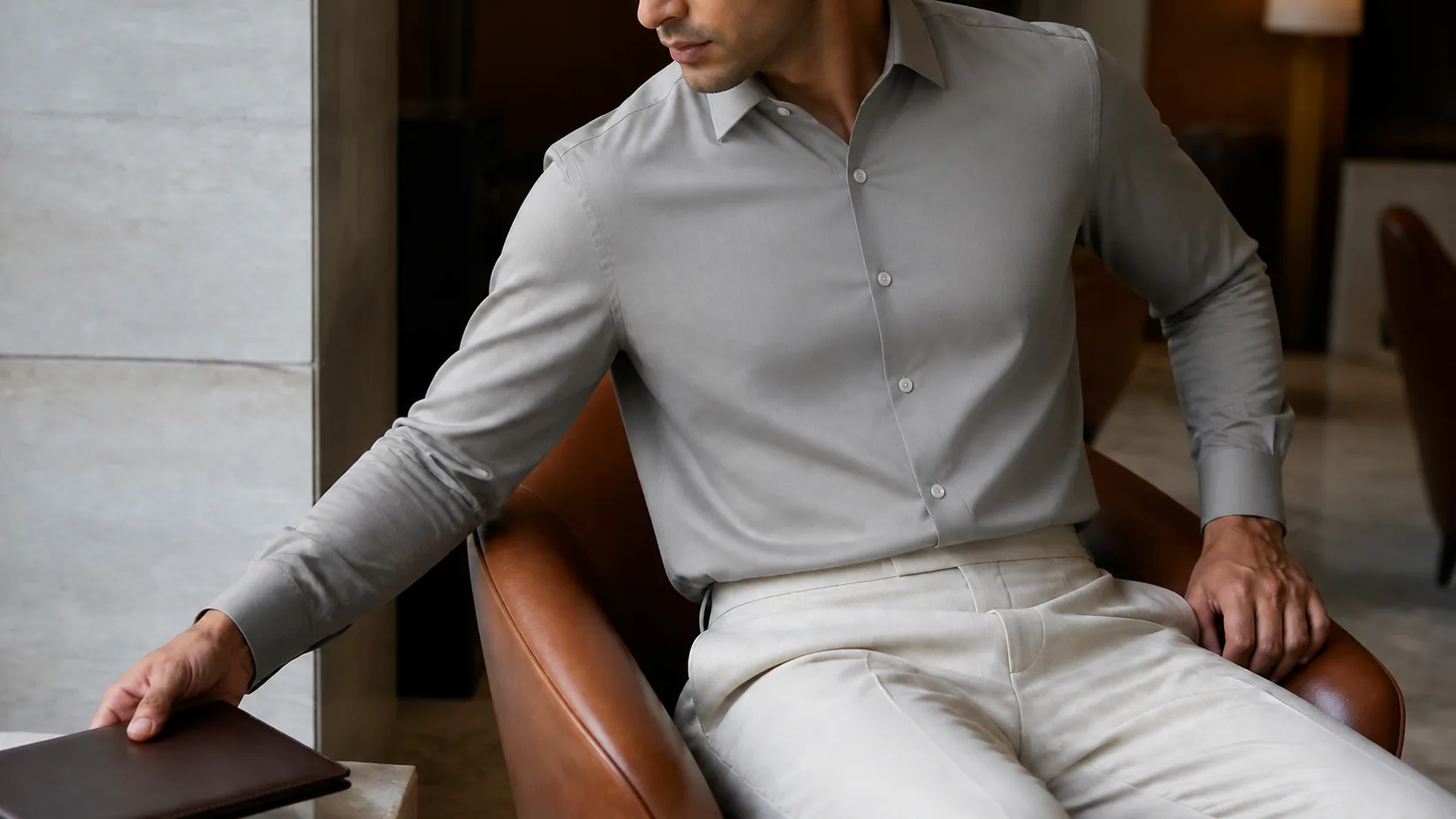 A man seated in a leather chair in a plain grey shirt, the shirt asking for no attention